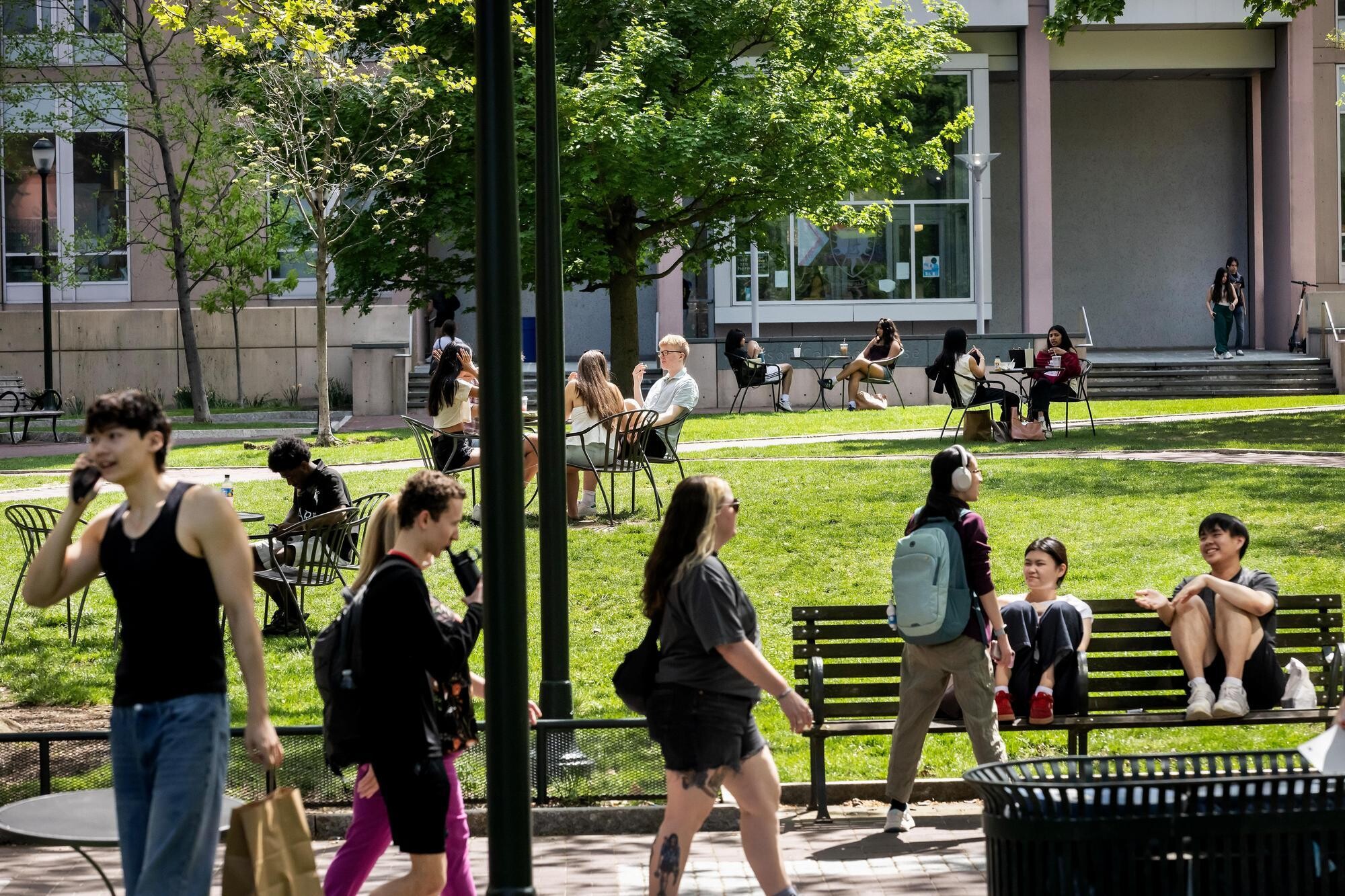 Students walking along and sitting on benches on Locust Walk.