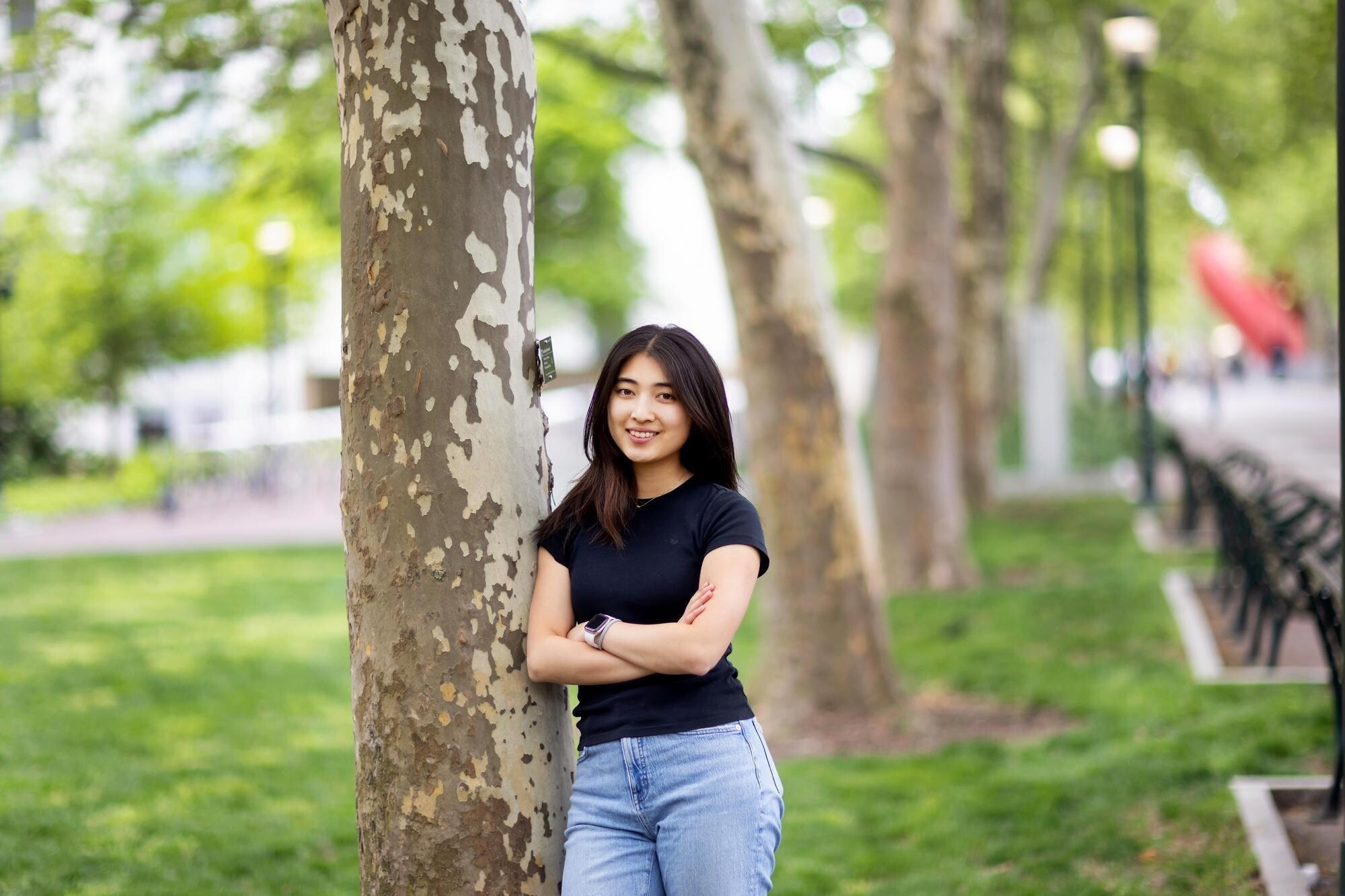 Margaret Zhu stands next to tree.