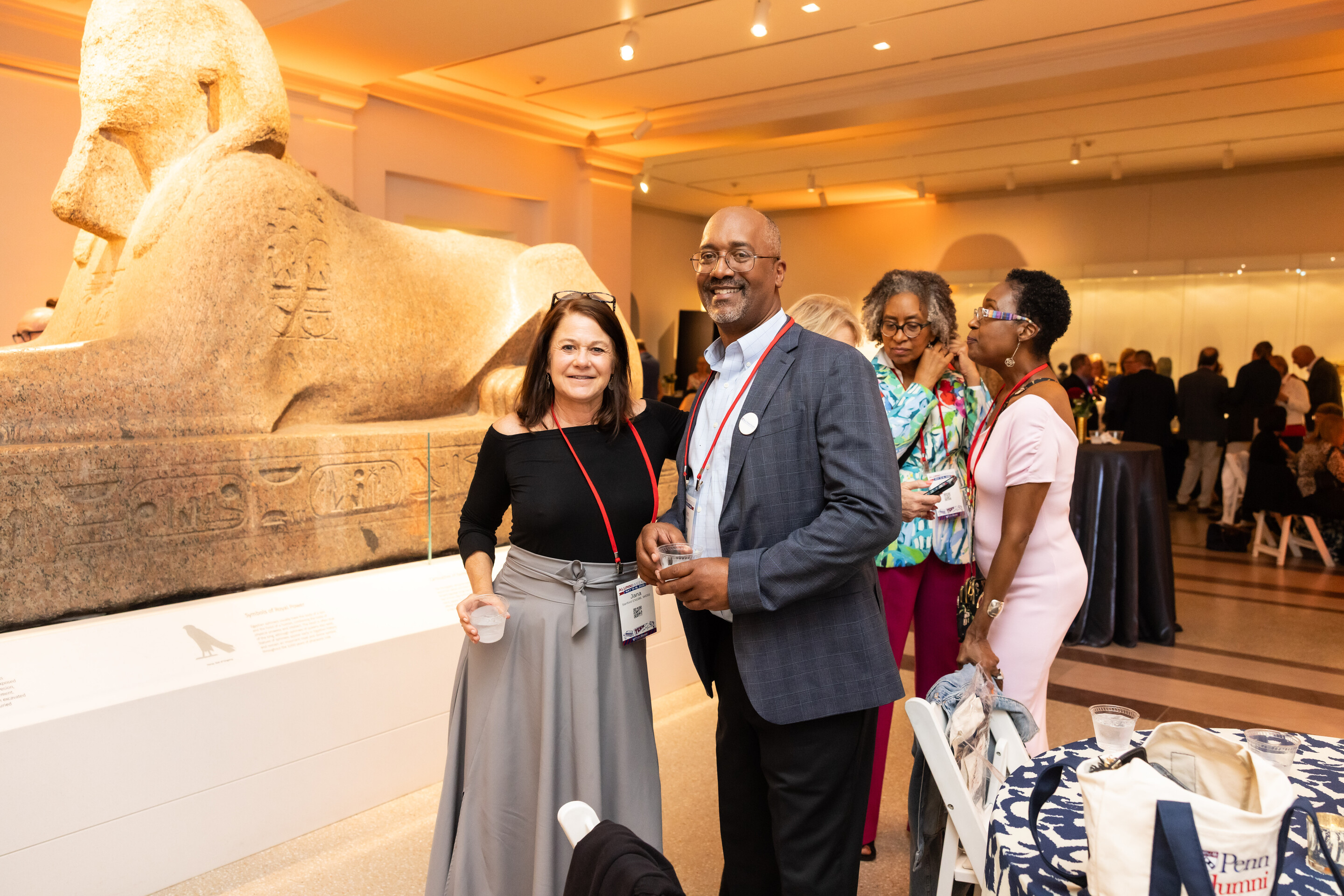 Two Penn alum in front of the Sphinx at the Penn Museum during Alumni Weekend.