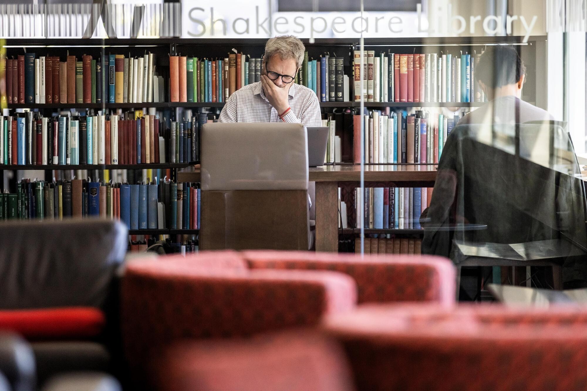 A person working on a laptop in the Shakespeare Library during Reading Days.
