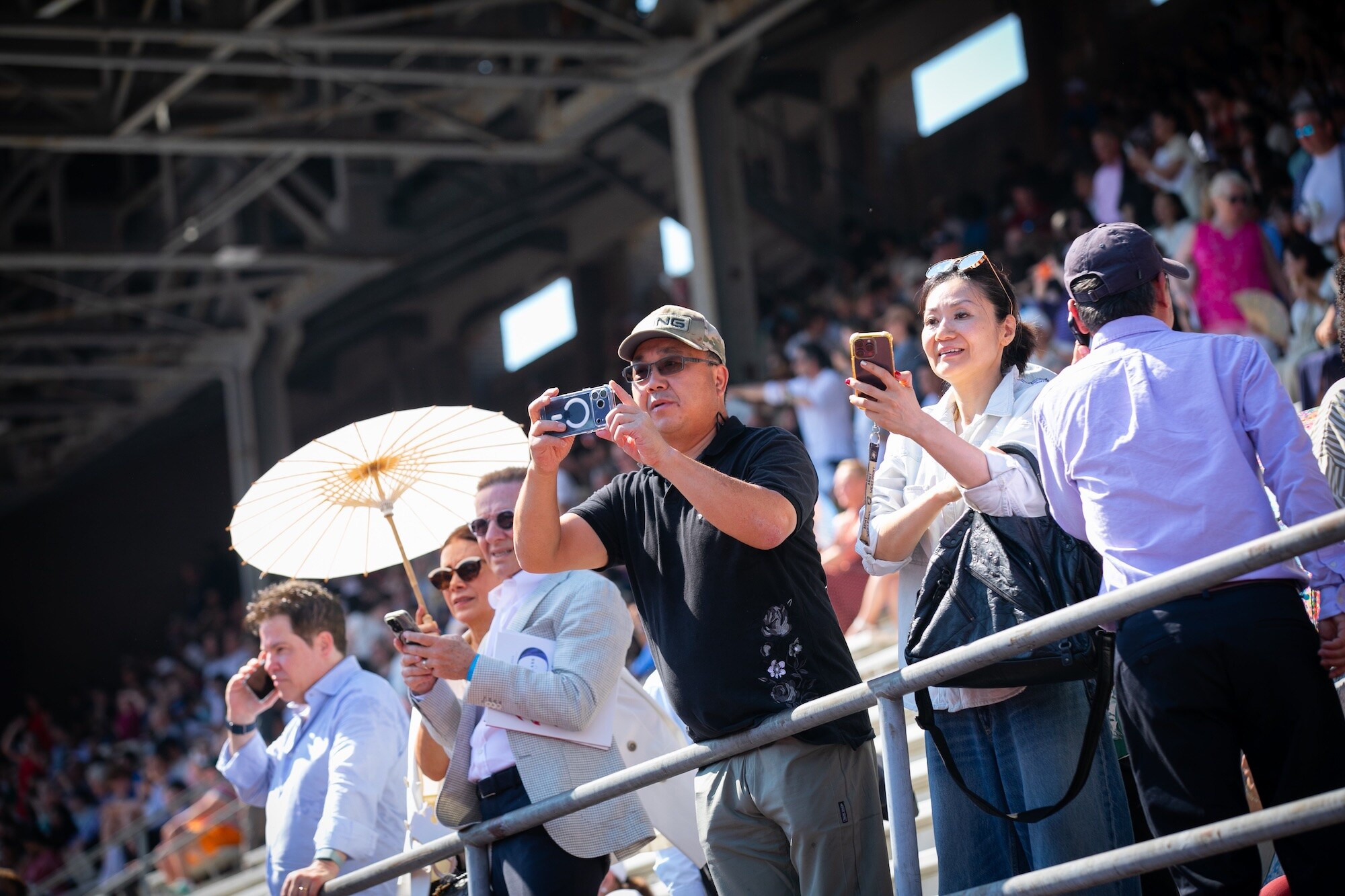 Spectators taking photos in the stands at Penn’s commencement.