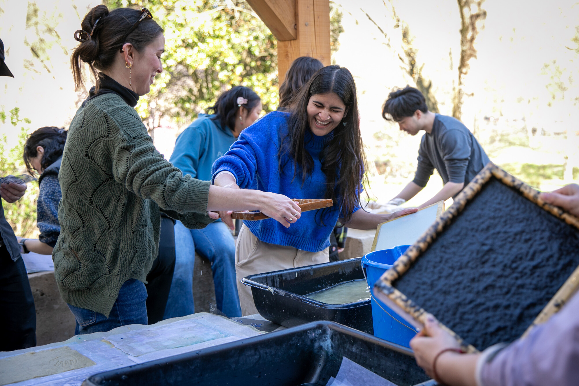 Students drain water from the paper pulp.