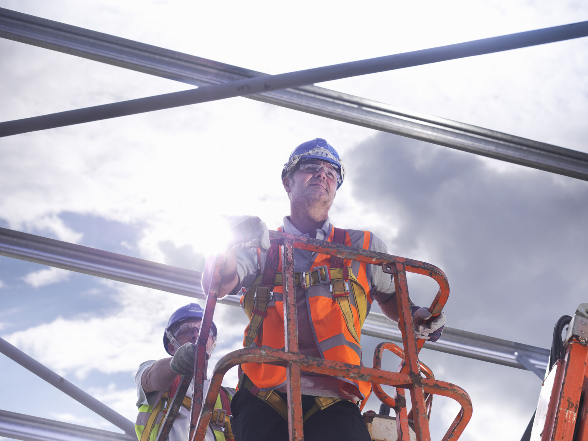 Workers work at a construction site under the hot sun.