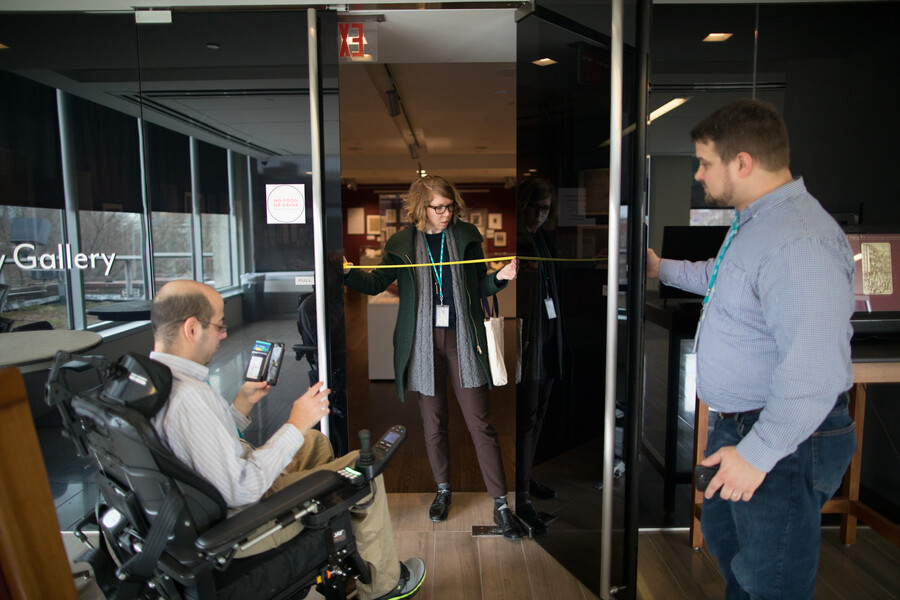 Mark Bookman, Alice McGrath, and a colleague take measurements for an entry to their accessibility map. 