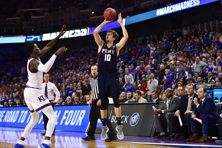 Penn player jumps with the ball in front of opponent