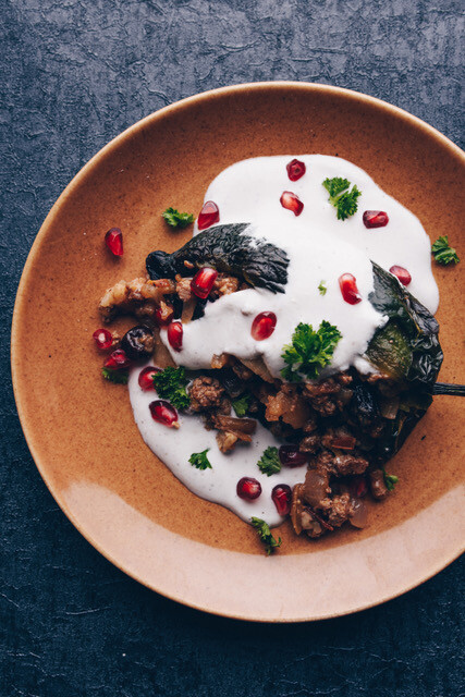 Chilis en nogada with a white sauce and sprinkled with pomegranates 