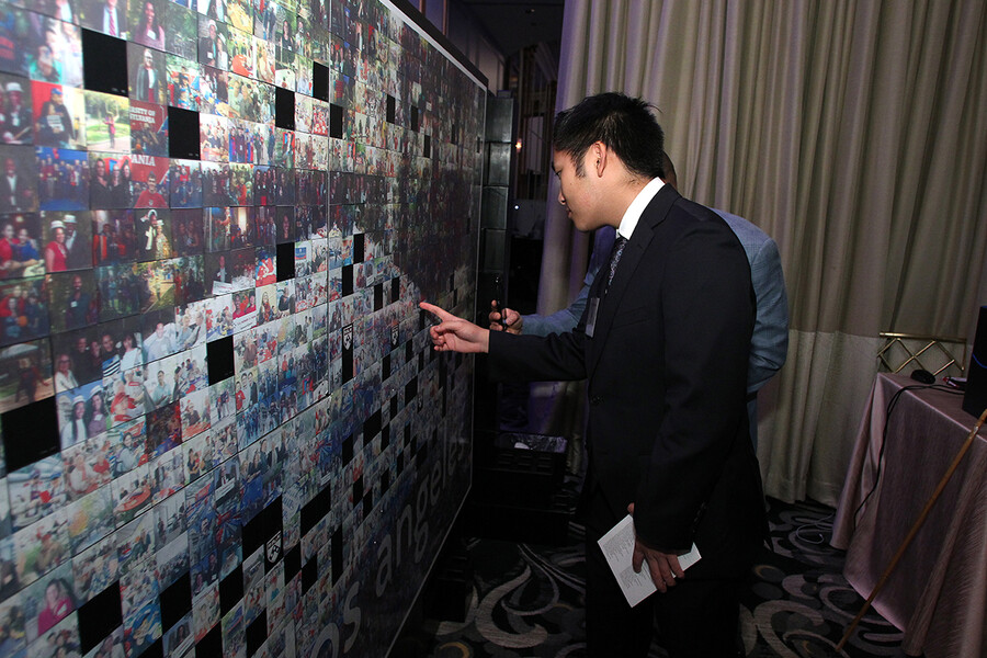 alumnus-viewing-wall-of-photos-at-power-of-penn