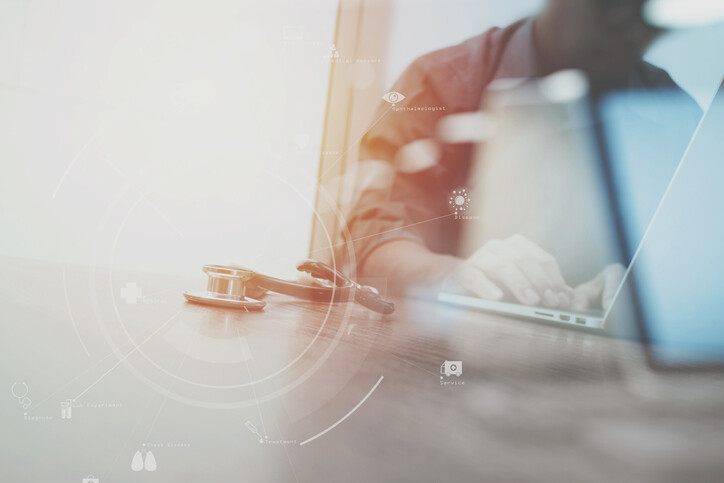 hands typing on a laptop with medical images in foreground