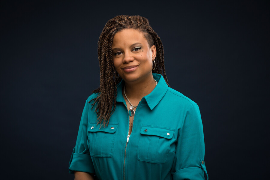 An African American woman wearing a teal green shirt