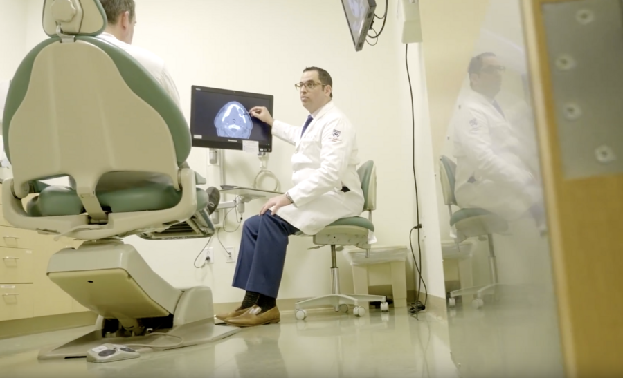 Rabie Shanti sits at a computer discussing a graphic with a patient seated