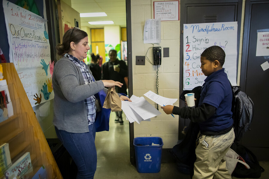 Karen Detlefsen takes papers from a student