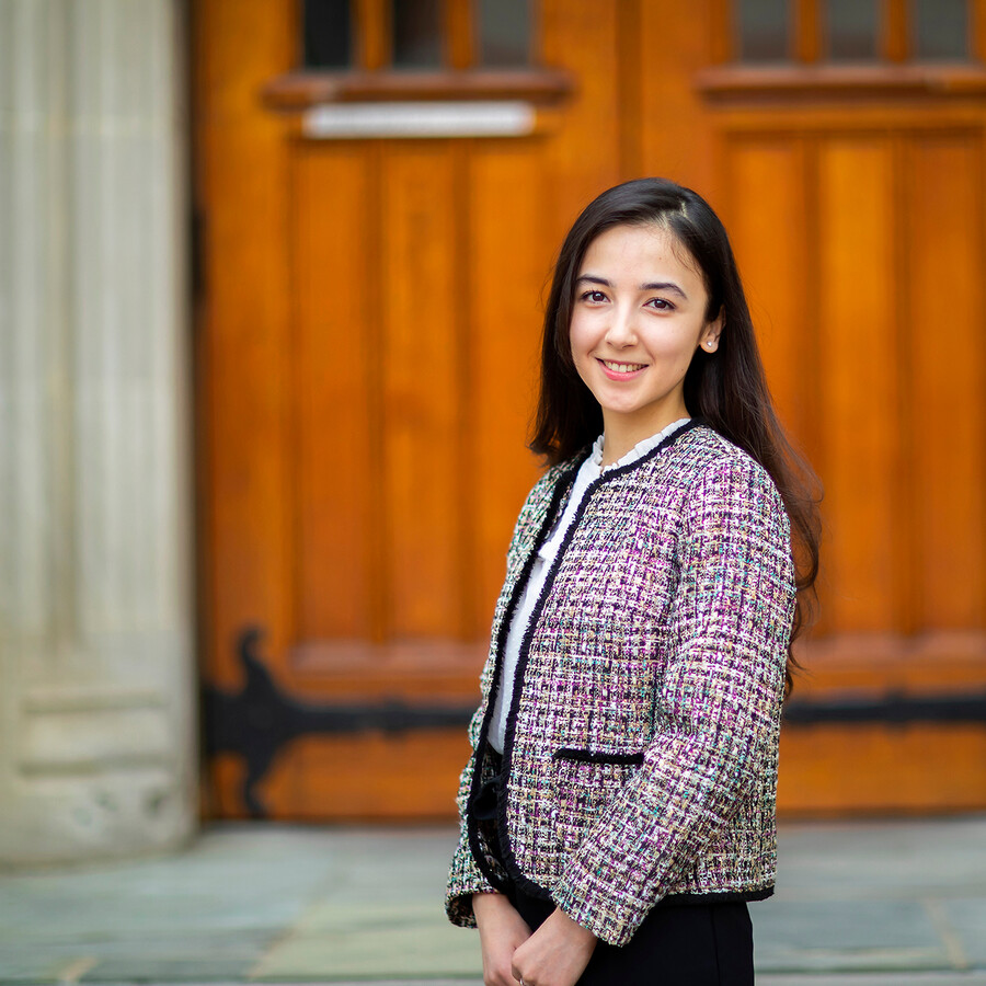 Shukurova posing in front of a wooden door