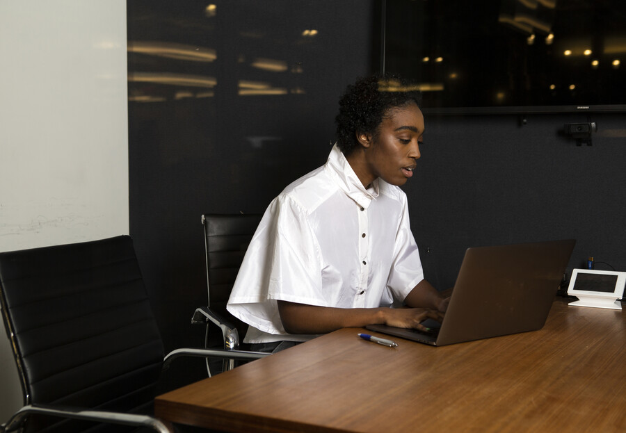 A non-binary person using a laptop at work.