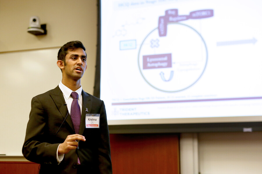 patel stands in front of a powerpoint slide