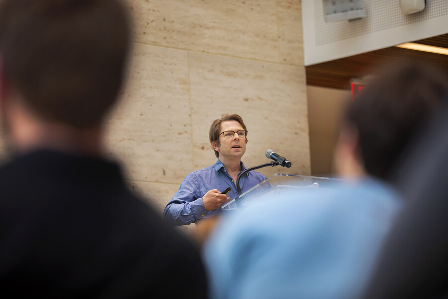 Roderick Coover speaking at microphone to audience 