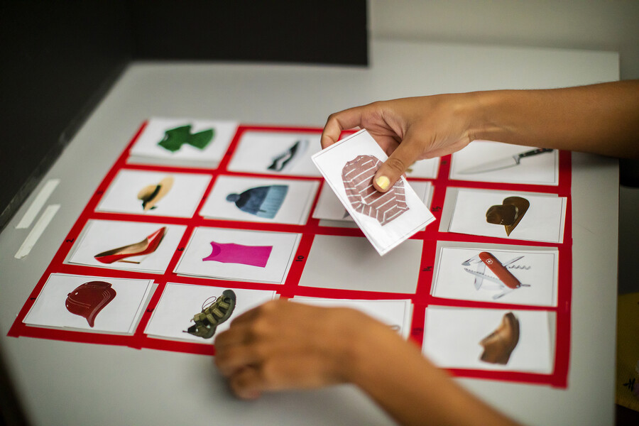 A four by four grid of cards with drawings of everyday objects like hats, shoes, shirts, and knives.