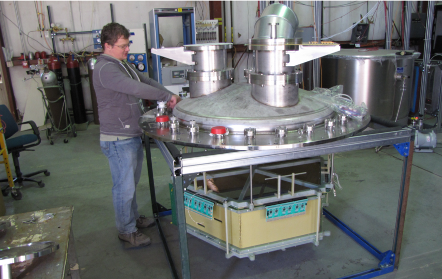a person stands next to a prototype detector in a lab