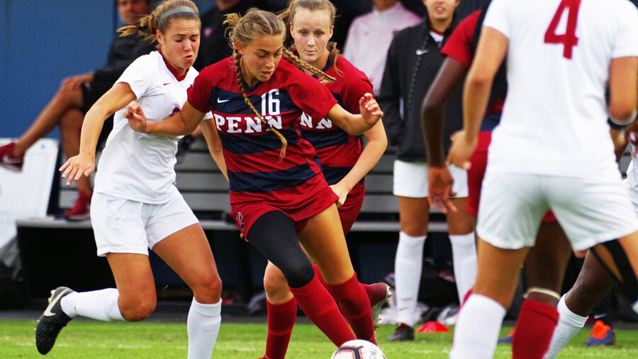 Breukelen Woodard moves with the ball between two defenders against Stanford.