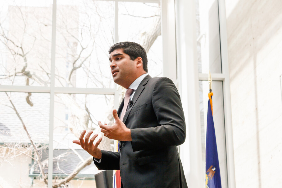 Person wearing a suit and a tie gestures with both hands.