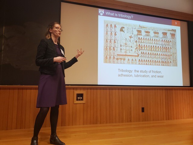 a person in front of a powerpoint presentation that says what is tribology and below tribology the study of friction, adhesion, lubrication, and wear