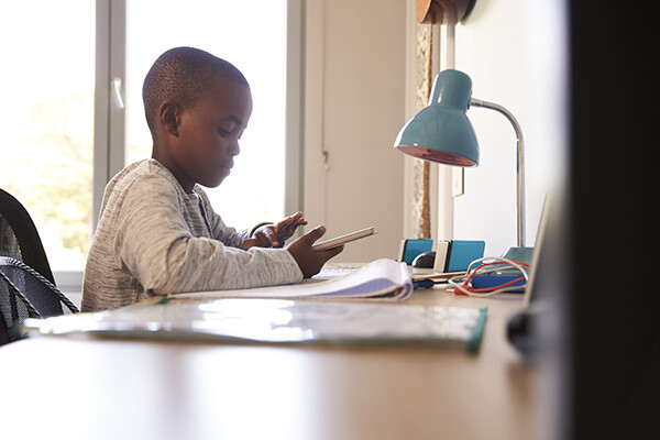 Young student working at home on tablet at a desk