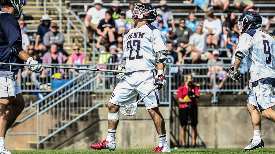 Sean Lulley standing on the field getting checked by opponent's defence stick