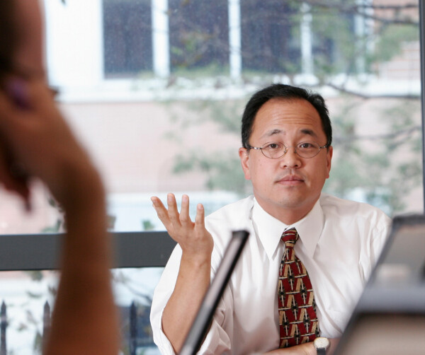 Christopher Yoo sits at a table 