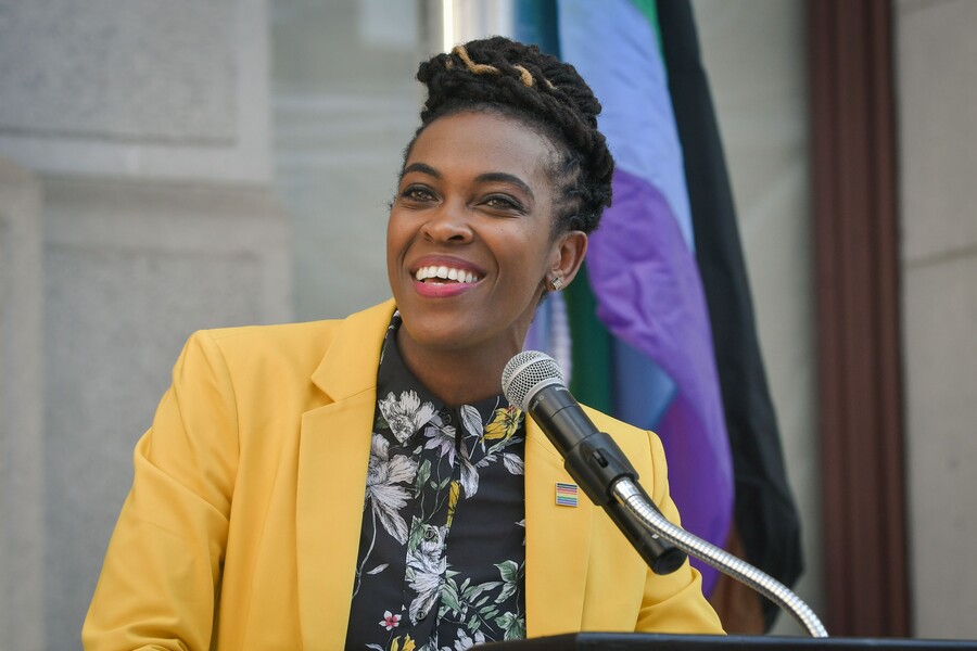 Woman in blazer speaks at a podium