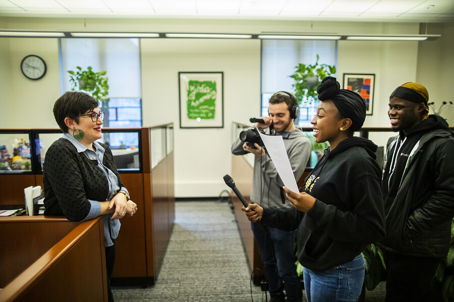 students interview a person in an office