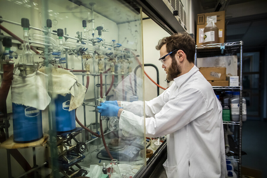 alex weberg adjusts hoses inside of a fume hood