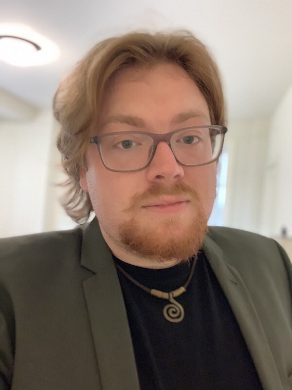 Person in glasses looks at the camera