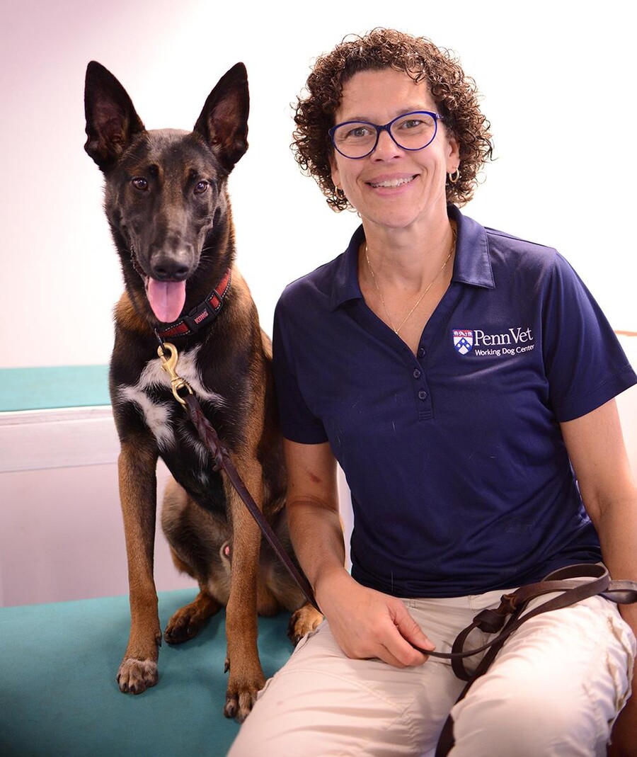 Cindy Otto smiling beside a large dog on a leash.