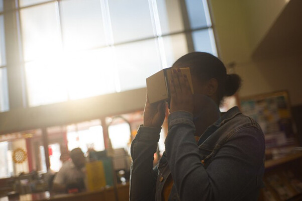 person holding a virtual reality headset to their eyes.