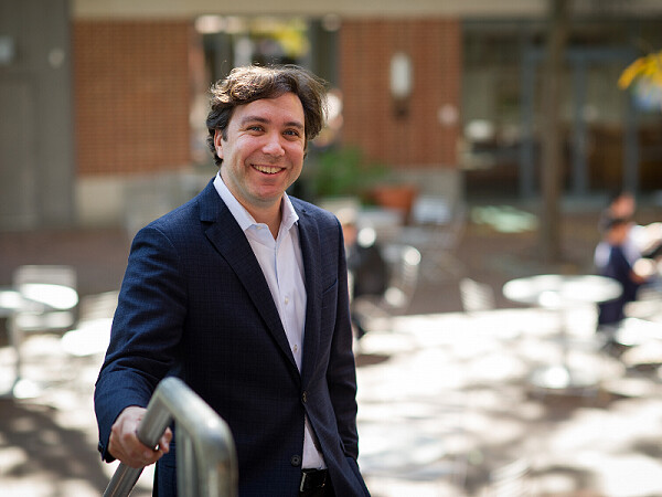 David Abrams smiles at camera walking up steps outside.