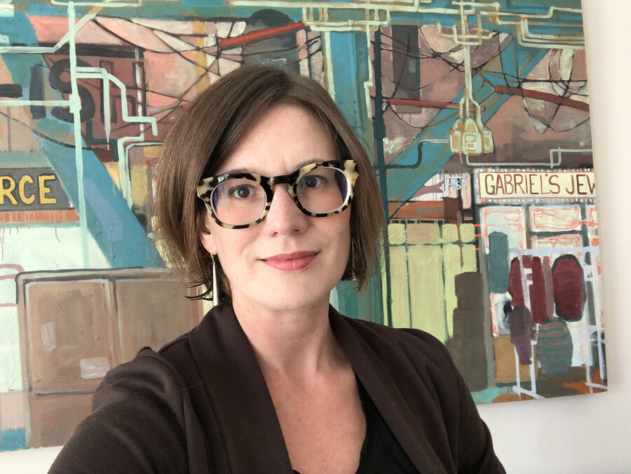 Rebecca Mueller standing in front of a mural on a wall