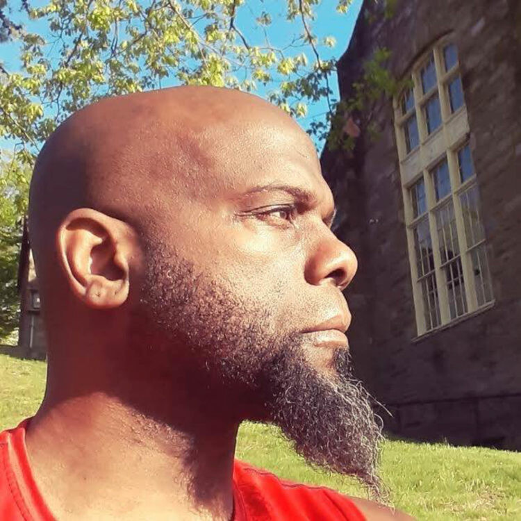 Man standing outside stone buildings