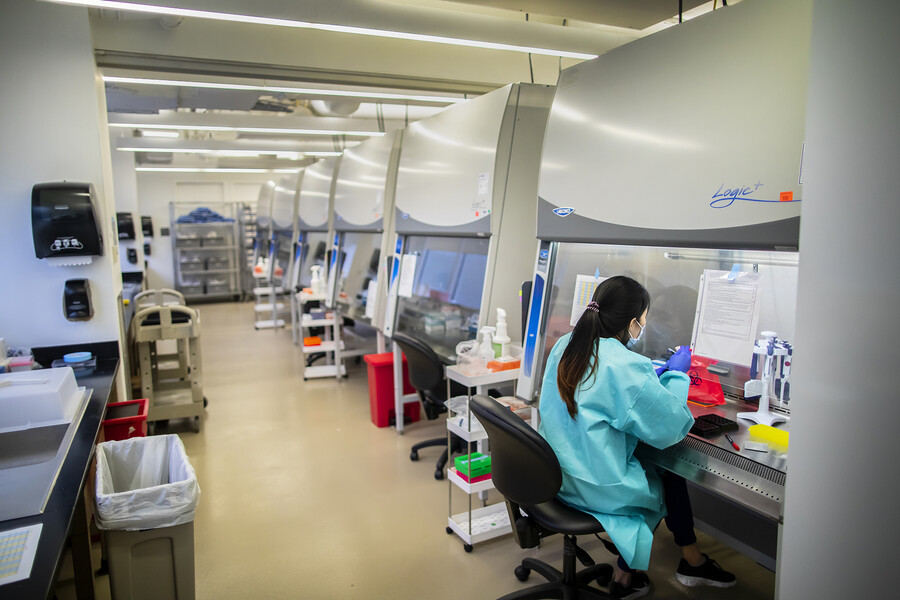 a person in a lab coat working in a fume hood
