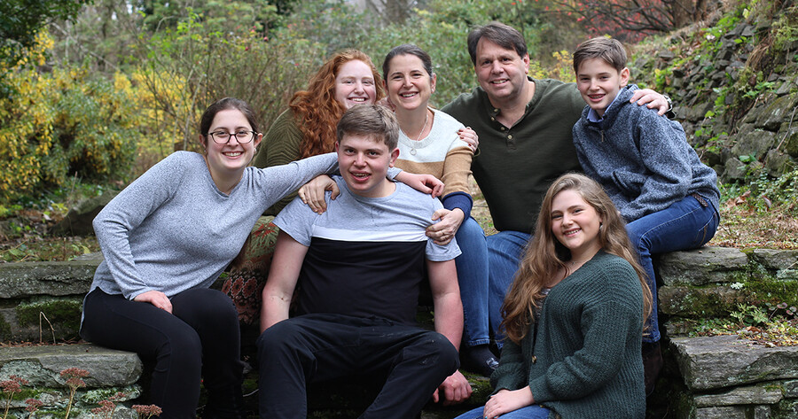 Amy Lutz seated with her husband and children in nature.