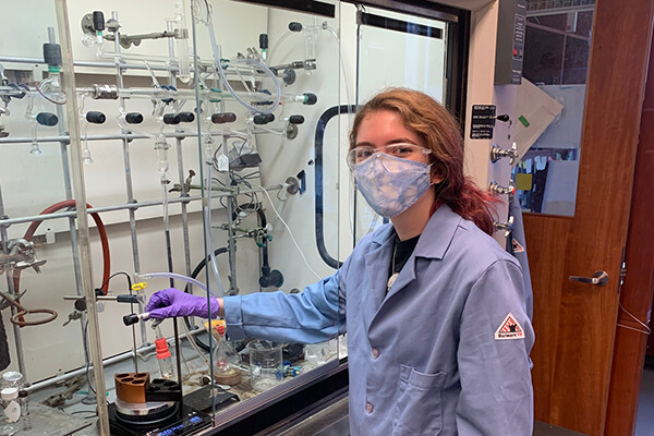 Calais Cronin wears a face mask in a chemistry lab.