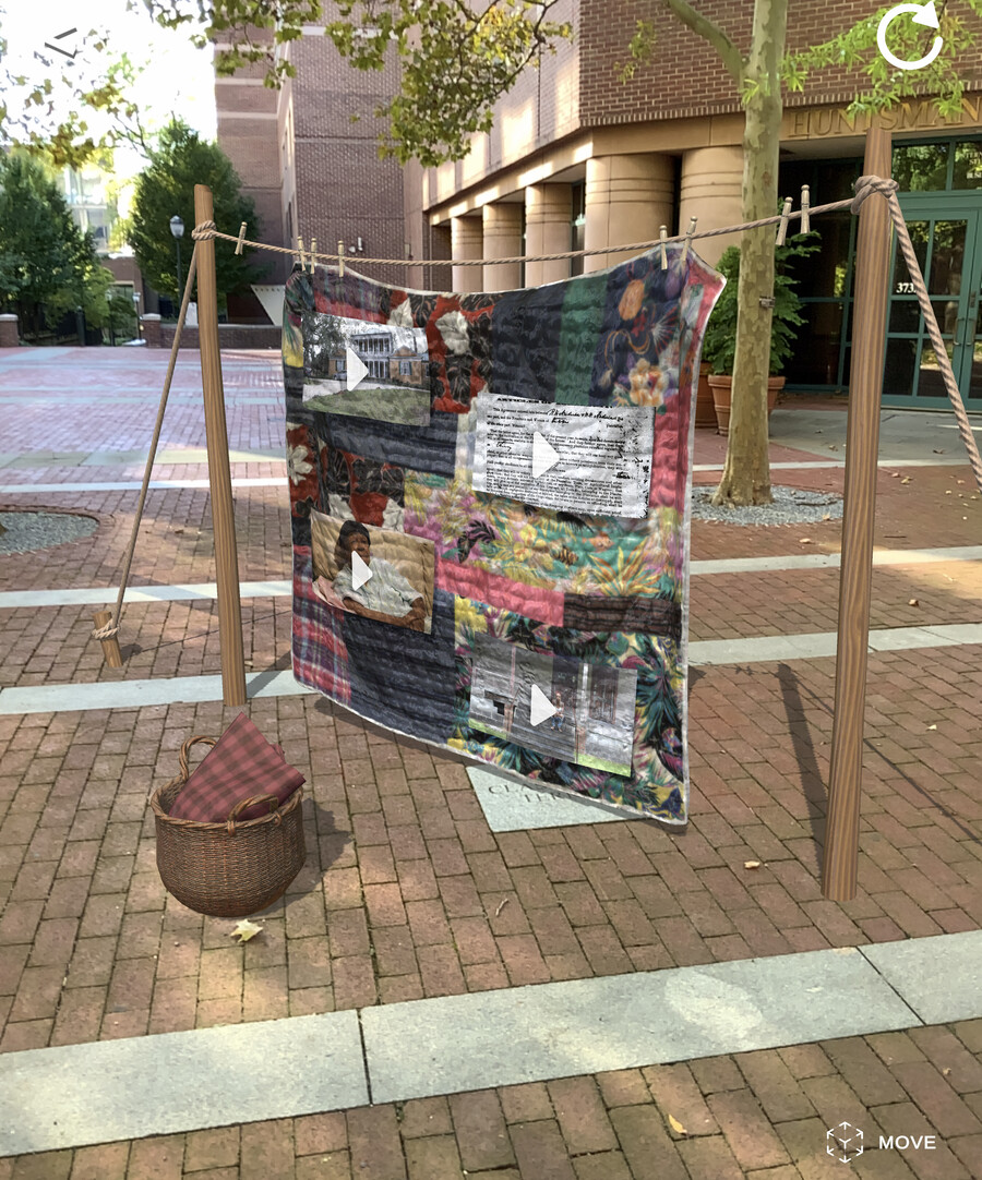 An image of the app depicting Breanna's family quilt with play buttons to watch videos