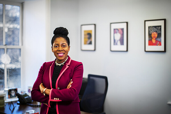 Sherisse Laud-Hammond stands with arms folded, smiling, in her office.