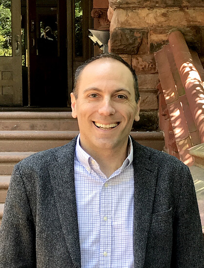 Vincent Reina smiles on a front door stoop.