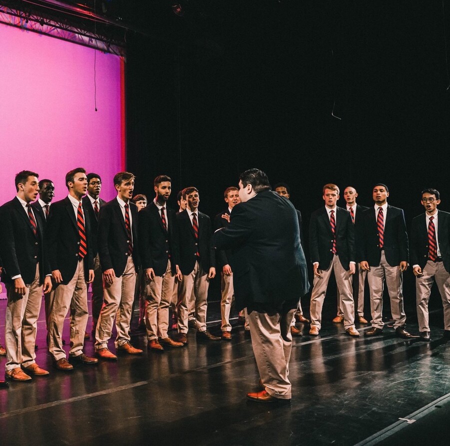 Several students singing while standing on a stage