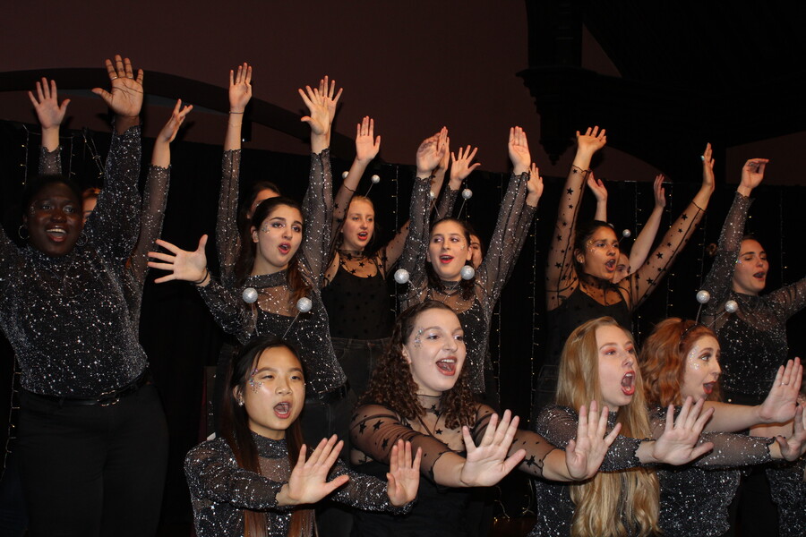 students singing with hands up