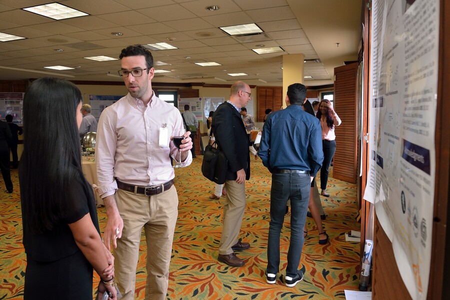 people standing in front of posters in a conference room