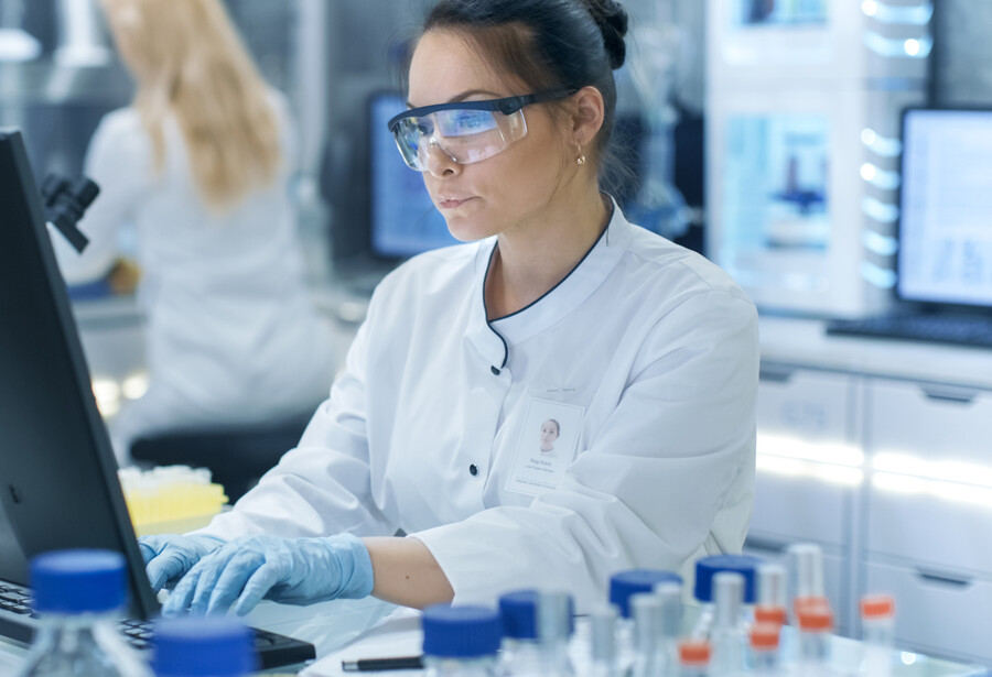 Female researcher working on a computer in a lab.