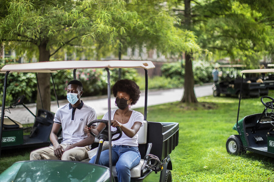 two students in a golf cart