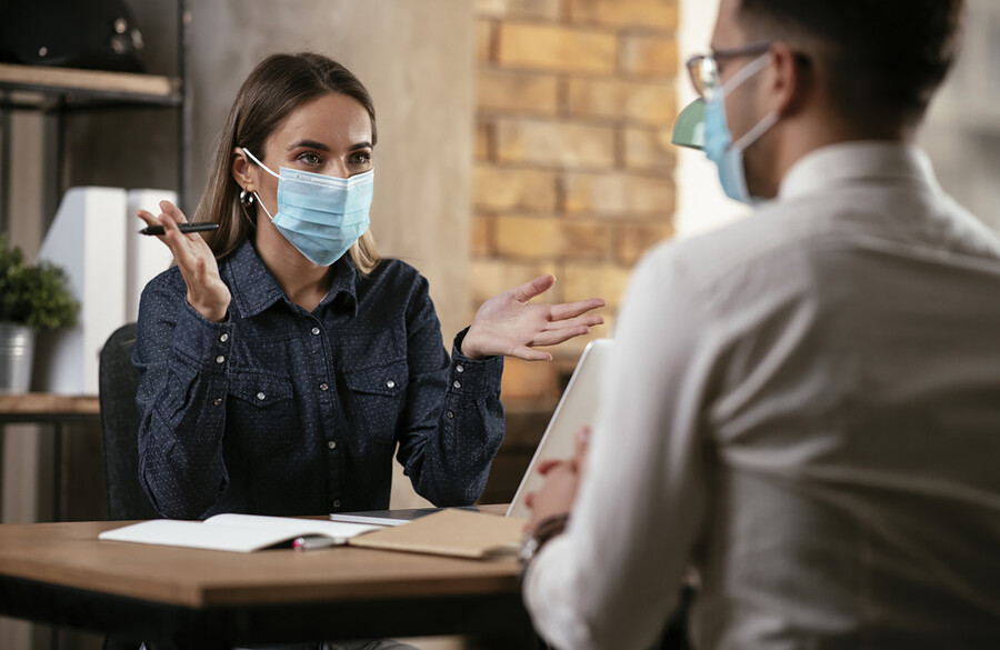 Businesspeople in conversation wearing face masks