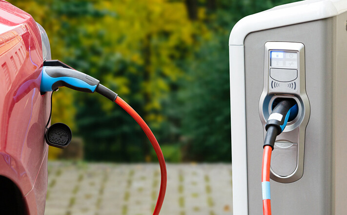 An electric vehicle plugged into a recharge station.
