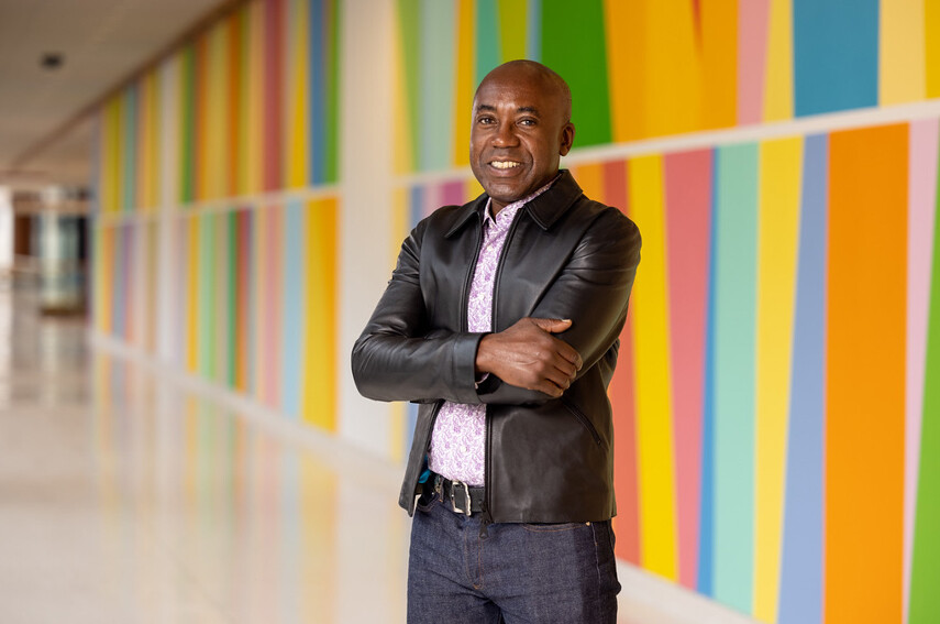 Odili Odita stands in front of his mural in the Penn Medicine Pavilion.